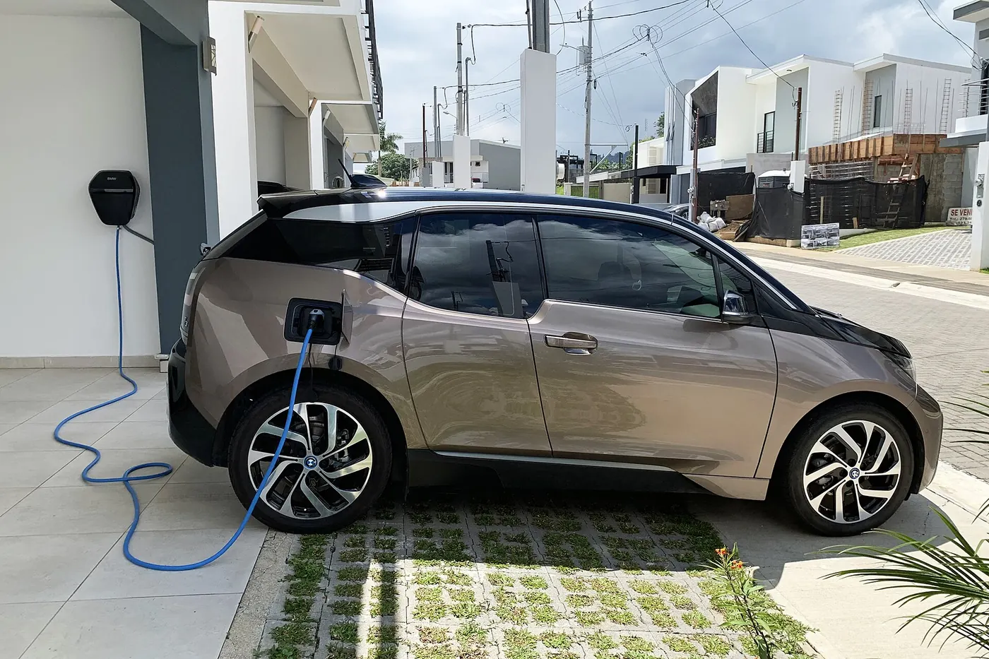 Voiture électrique en charge dans l'allée d'une maison